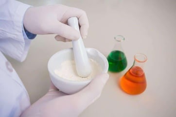 Scientist grinding powder with mortar in the laboratory